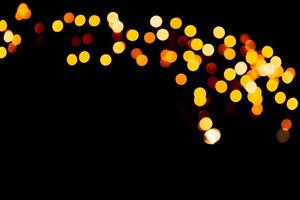 Unfocused abstract orange bokeh on black background. defocused and blurred many round light photo