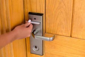 Woman hand with keycard in the electronic lock. female hand hold key card and open electronic lock door photo