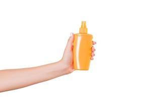 mano femenina sosteniendo una botella de crema de loción aislada. Chica dar productos cosméticos sobre fondo blanco. foto