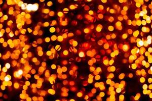 Unfocused abstract orange bokeh on black background. defocused and blurred many round light photo