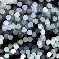 Abstract bokeh of white city lights on black background. defocused and blurred many round light photo