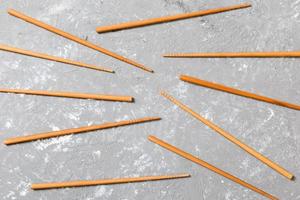 Many bamboo chopsticks on black cement stone background, top view with copy space. a lot of sushi sticks in the form of an ornament photo