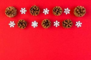 Top view of New Year ornament made of white snowflakes and pine cones on colorful background. Winter holiday concept with empty space for your design photo