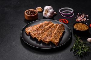 Tasty meat brawn or roll on a wooden cutting board with spices and herbs photo