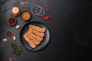 Tasty meat brawn or roll on a wooden cutting board with spices and herbs photo