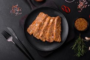 Tasty meat brawn or roll on a wooden cutting board with spices and herbs photo