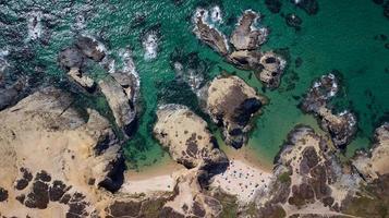 vista aérea de drones de la concurrida playa en algarve, portugal durante las vacaciones de verano. destinos asombrosos. viajes y aventuras. vacaciones en la playa. viajes exóticos. lugares más visitados. foto