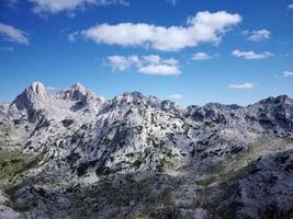 vista aérea de drones de diferentes picos de montaña durante un hermoso día soleado con un valle verde debajo. conexión con la naturaleza, más aventura en la vida. montaña prenj en bosnia y herzegovina. foto