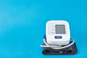 Digital blood pressure monitor on a blue background photo