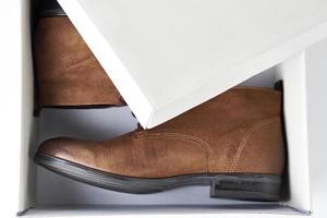 par de nuevas botas de mujer de cuero marrón en caja abierta foto