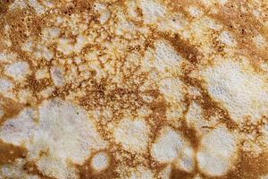 Pancake surface texture and pattern. Close-up of thin hot pancakes in a plate. Traditional rustic food. Graphic resource. photo