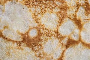 Pancake surface texture and pattern. Close-up of thin hot pancakes in a plate. Traditional rustic food. Graphic resource. photo