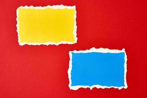 Two ripped paper torn edge sheets on a red background. photo