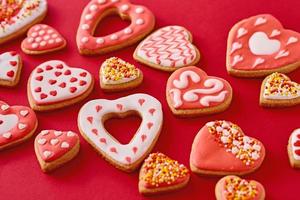 Background of decorated with icing heart shape cookies on red background photo
