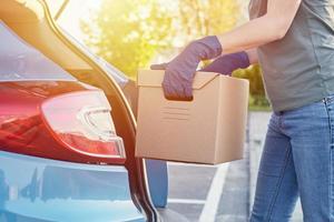 concepto de servicio de entrega. mujer cargando caja en coche foto