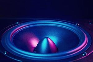 Sound audio speaker with neon lights on dark background photo