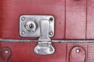 Part of vintage retro suitcase. Closeup view of lock on old suit case photo