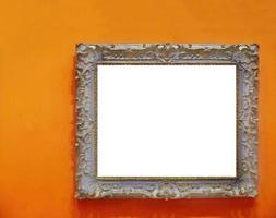 Beautiful antique wood carving empty photo frame isolated on orange colored wall, cutout, copy space, clipping path