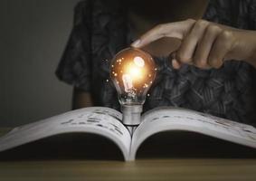 Businesswoman holding a light bulb, Creative new idea. Innovation, brainstorming, solution and inspiration concepts. imagination, creative thinking problem solving. photo