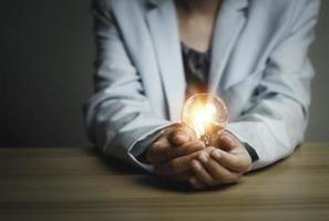 Businesswoman holding a light bulb, Creative new idea. Innovation, brainstorming, solution and inspiration concepts. imagination, creative thinking problem solving. photo