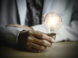 Businesswoman holding a light bulb, Creative new idea. Innovation, brainstorming, solution and inspiration concepts. imagination, creative thinking problem solving. photo