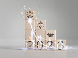 Developing ideas for the new year 2023 using square wooden blocks placed on the table. creative idea Business start-up, planning, systematic management photo