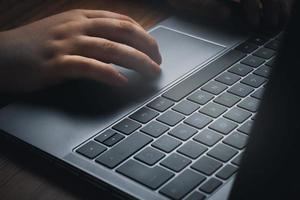 Side view of woman hands using laptop on vintage wood desk. Business, finance and gaming concept. Work from home. Workplace. photo