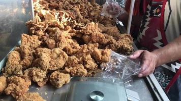 foco seletivo de embrulhar frango frito crocante, comida de rua na indonésia video