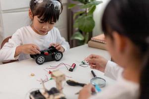 Asia students learn at home in coding robot cars and electronic board cables in STEM, STEAM, mathematics engineering science technology computer code in robotics for kids concept. photo