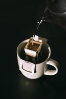 The process of brewing coffee. Water is poured into a drip coffee bag in a mug. Trends in brewing coffee at home photo