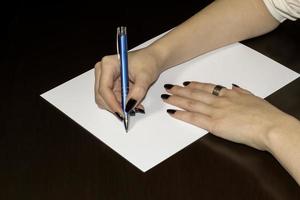 Women hands writing on white paper. Clear blank photo