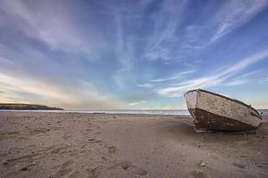 lonely old boat on the beach photo