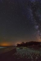 night sky with stars and milky way over beach photo
