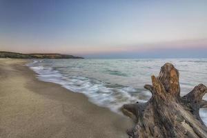 temprano en la mañana en la playa con derrame de olas foto