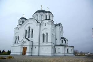 A large white stone church with a golden dome and a bell in eastern Europe is a Christian orthodox for the prayers of God photo