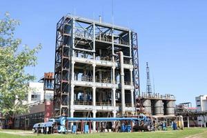 A large concrete technological industrial installation at a chemical petrochemical refinery with capacitive pipes by pumps compressors heat exchangers by pipelines and buildings photo