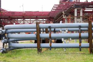 un gran caballete de tuberías de metal de hierro con tuberías y cables eléctricos y equipos en la refinería industrial de refinería petroquímica foto