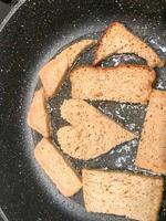 el pan de centeno se fríe en una sartén con aceite, picatostes, suhariki en forma de corazón foto