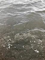 textura de agua fría negra oscura con olas de ondas onduladas. el fondo foto