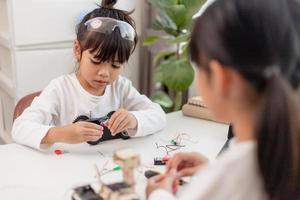 Asia students learn at home in coding robot cars and electronic board cables in STEM, STEAM, mathematics engineering science technology computer code in robotics for kids concept. photo