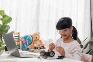 Asia students learn at home in coding robot cars and electronic board cables in STEM, STEAM, mathematics engineering science technology computer code in robotics for kids concept. photo