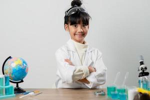 concepto de educación, ciencia, química y niños - niños o estudiantes con tubos de ensayo haciendo experimentos en el laboratorio escolar foto