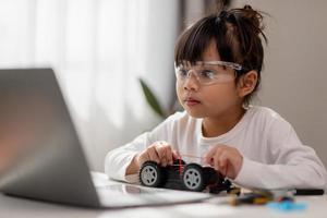 Asia students learn at home in coding robot cars and electronic board cables in STEM, STEAM, mathematics engineering science technology computer code in robotics for kids concept. photo