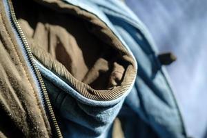 Fragment of a hooded vest with a zipper for clothing, in natural sunlight. Clothing repair concept. photo