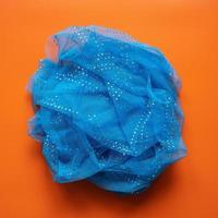 Crumpled transparent blue scarf on red background. Top view. photo