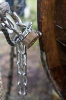 el candado y la cadena de metal protegen la propiedad privada del robo, en un fondo borroso. de cerca. foto