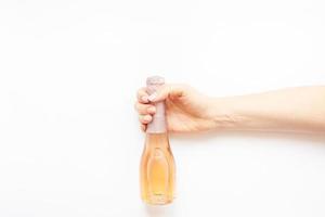 botella de vino de champán rosado en mano de mujer foto