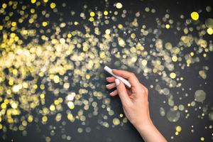 Woman hand with golden bokeh lights on background photo