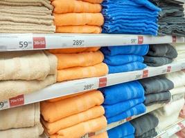 Shelves in the store. Laying out goods in a supermarket. Sale of towels. photo