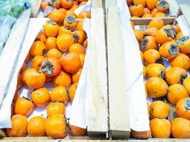 Honey persimmon on the counter. Sale of fruits in the store. photo